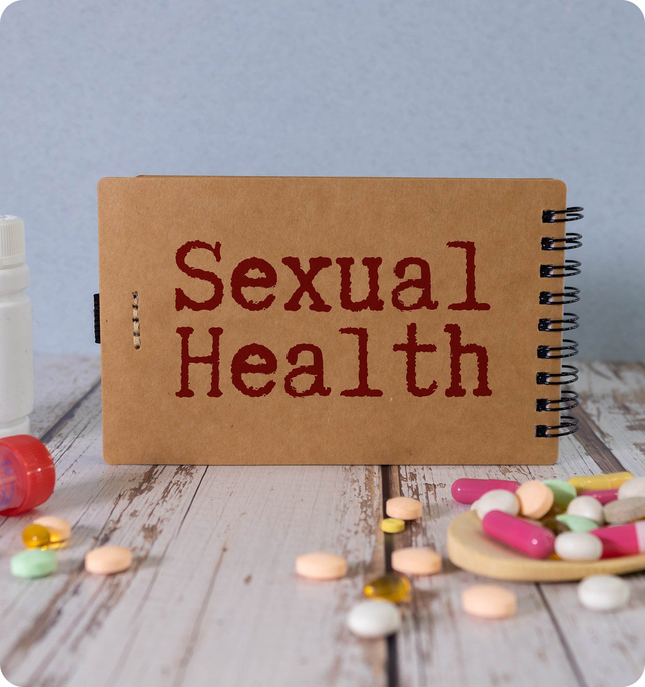 Notebook labeled "Sexual Health" with pills nearby.