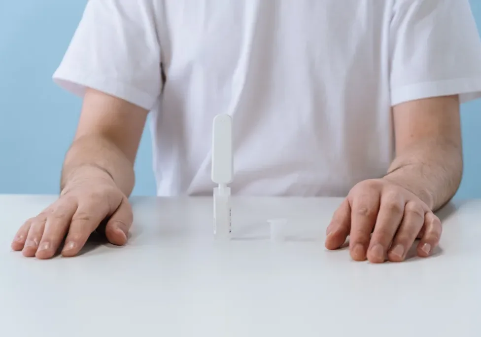 Person using an OraQuick HIV rapid self-test kit at a table